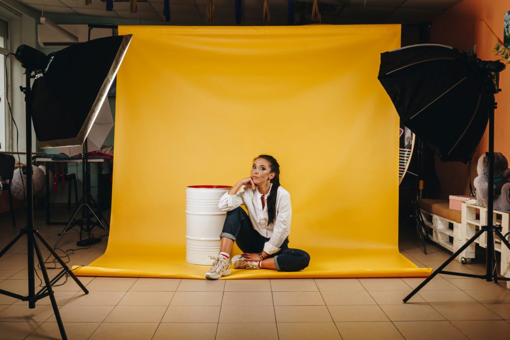 Portrait de femme sur fond jaune dans un studio photo chez soi